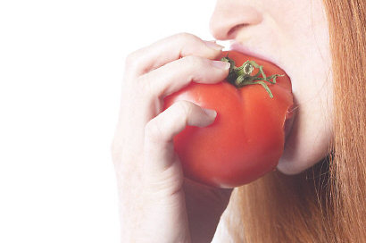 Woman biting tomato uid 1343064