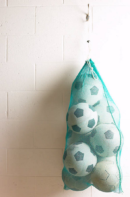 Net of soccer balls on gym wall